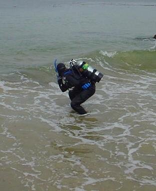 diver entering the water through the surf
