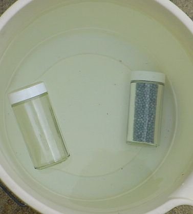 Image of a floating empty glass jar and a sinking jar filled with lead