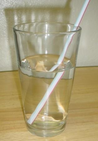 Straw in a glass of water, refraction clearly visible with the straw